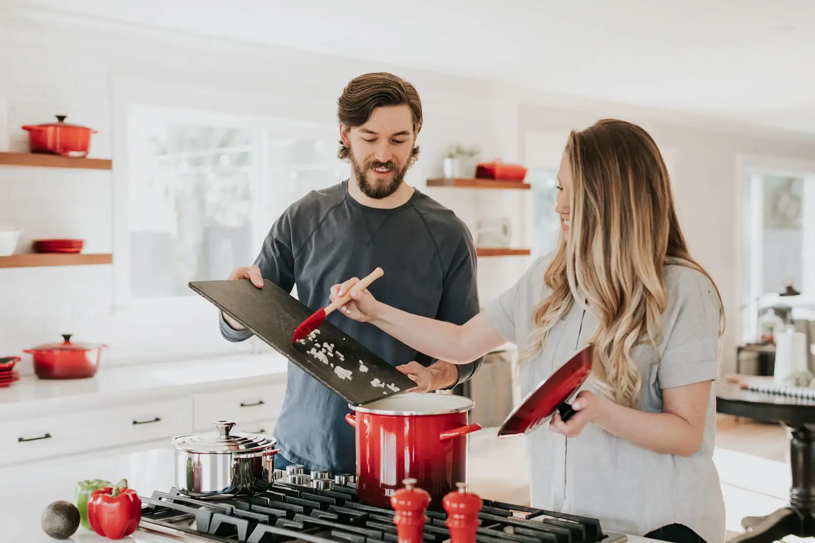 Two people cooking at a gas range in a white kitchen. Shown on the homepage for Arlington, TX.